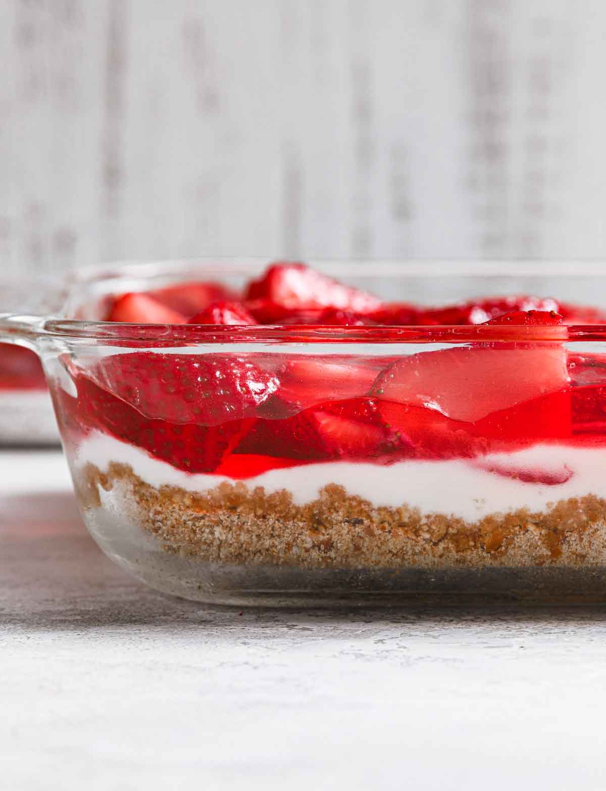 Side view of strawberry pretzel salad in a glass baking dish.
