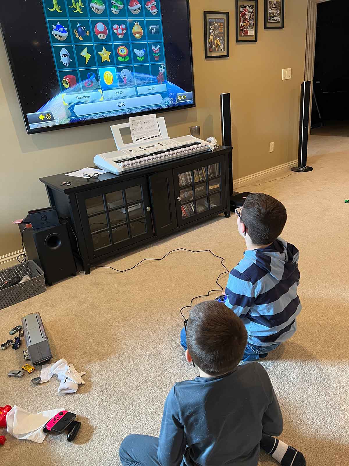 Two boys sitting in front of a TV playing video games.