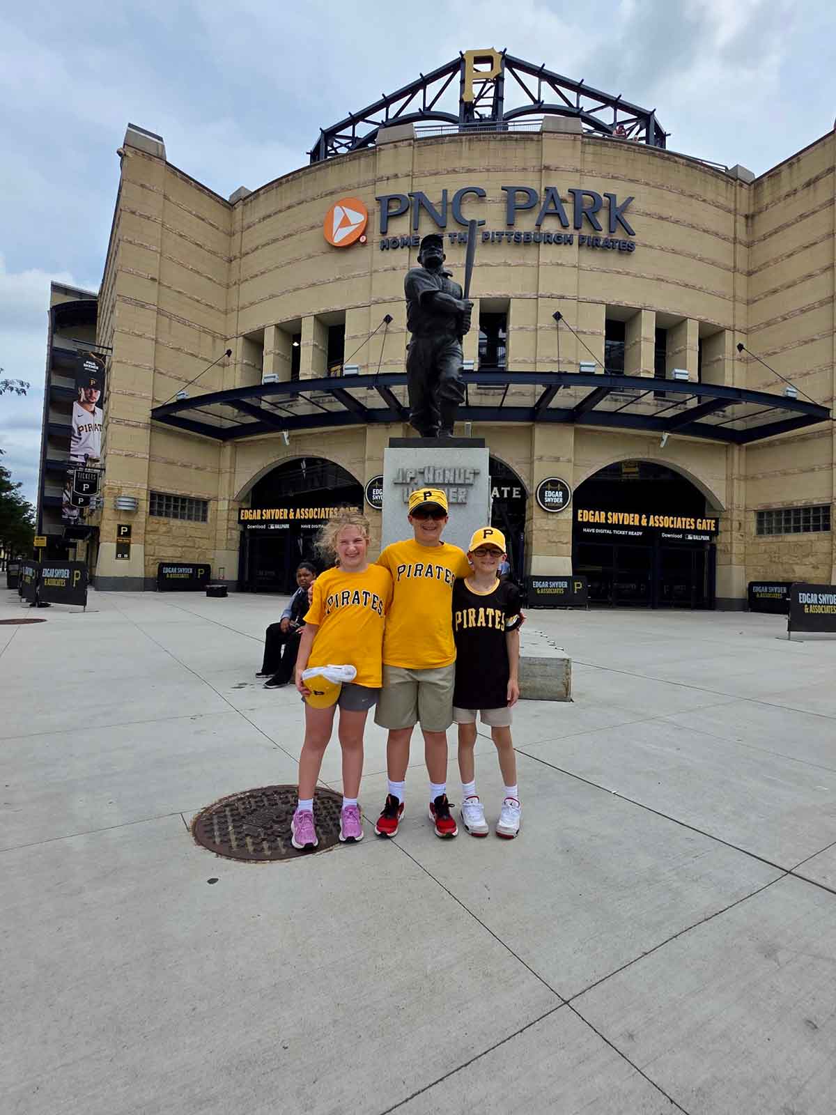 Three kids standing outside the entrance to PNC Park.